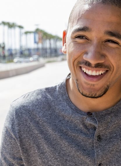 Portrait of a smiling young man standing in a street.